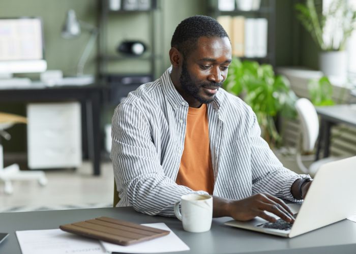 Man on laptop learning about debt review termination